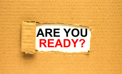 The text Are You Ready appearing behind torn brown paper