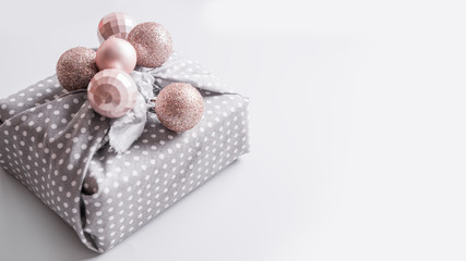 Banner of Christmas sustainable gift decorated pastel silver balls on grey. Xmas greeting card. Happy New Year.