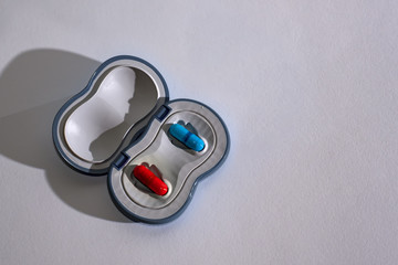 Red and blue capsules in case on white background, Red pill or blue pill: Wake up to the truth or...