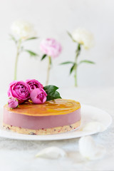 Homemade mousse cashew cake with orange and cherry, garnished with roses and peonies. Sugar, lactose, gluten free. Healthy food, vegan.