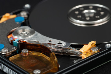 Disassembled laptop hard disk drive, hdd. Close-up. Opened hard drive, magnetic heads and disk...