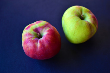 Two red and yellow ripe apples on a black background