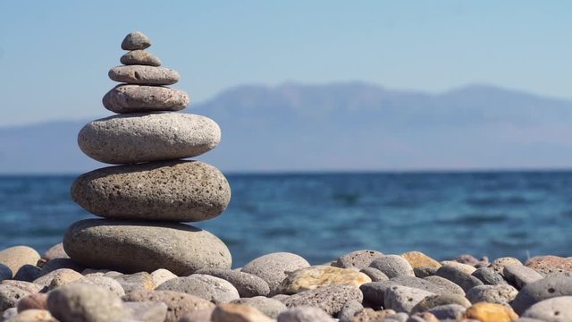 Stack of zen stones on beach near sea