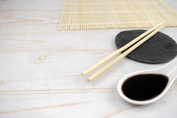 Japanese kitchen background with bamboo mat, chopsticks, soy sauce
