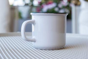Coffee cup mockup on a table, blur green background.