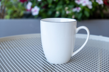 Coffee cup mockup on a table, blur green background.