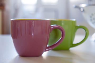 Coffee cup mockup on a kitchen table, blurred background.