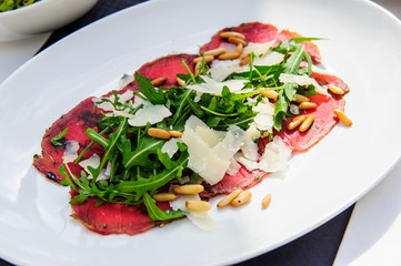 Fresh italian caprese salad with mozzarella and tomatoes on dark plate