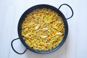 Chicken curry paella in a traditional spanish pan.