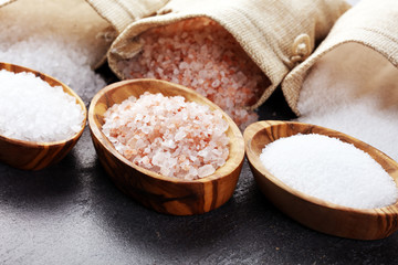 Sea salt and himalayan on spoon. Crystals of salt on background