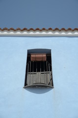 Naklejka premium window on blue wall at posada, sardinia, italy