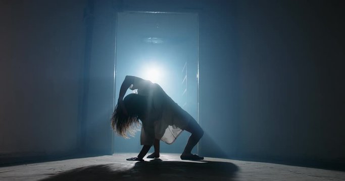 Scary female psychopath crawling in corridor of cursed house with unnatural moves. Exorcist girl awaken by demon - halloween concept 4k footage