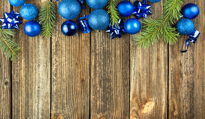 Christmas composition. Frame made of Christmas blue toys, pine branches on a wooden background. Flat lay, top view, copy space.