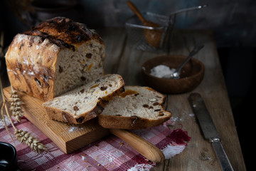 Freshly baked bread with nuts and dried apricots. Sliced ​​bread on a wooden table
