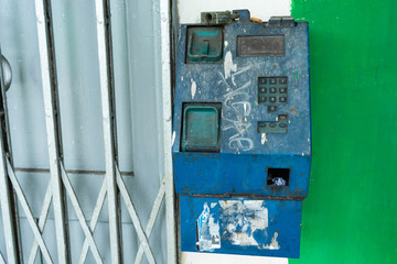 Fototapeta na wymiar Old broken payphone. Traces of poverty and devastation.