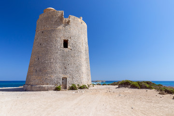 Fototapeta na wymiar Beautiful view of the old observation tower Torre De Ses Portes on the coast of the Ibiza island.