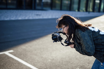 A professional female photographer is taking pictures of the city