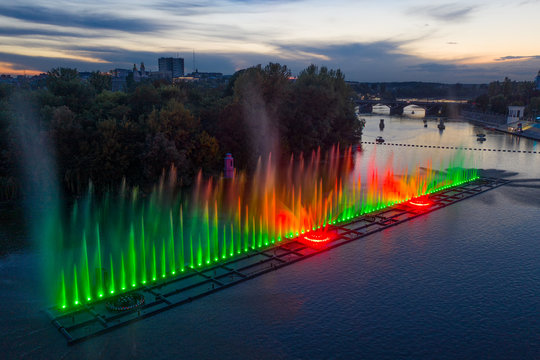 Colored fountain on the river at night.