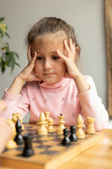 dad and little daughter play chess in an intelligent cafe