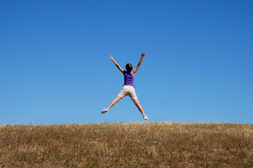 happy young woman jumping in the field