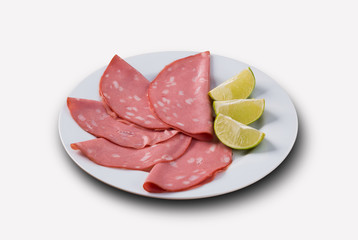 slices of mortadella served with lemon .. top view