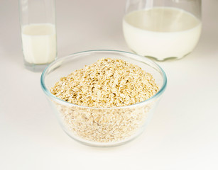 oatmeal in a glass plate next to a jug of milk.