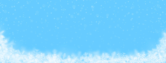 Christmas background of snowflakes of different shapes, sizes, blur and transparency on light blue background