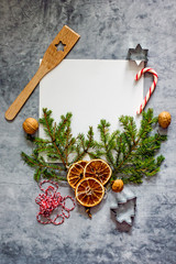Christmas food recipe background. A book for writing recipes on a dark table surrounded by fir branches, Baking ingredients. Top view, flat lay, copy space