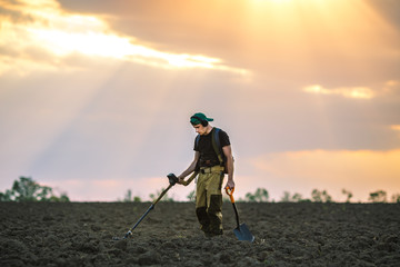 Treasure hunter in the field with metal detector