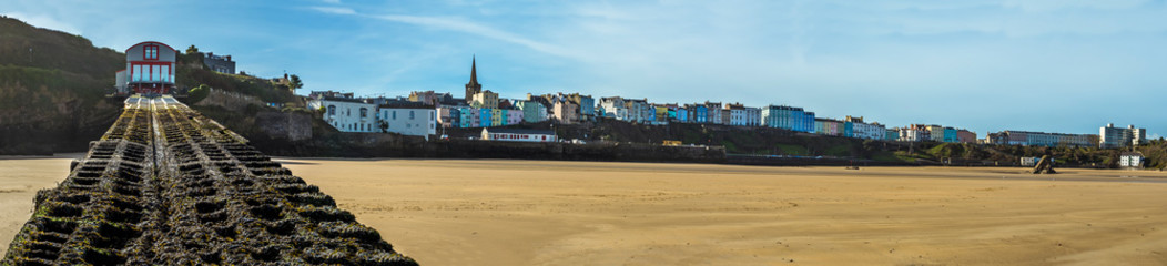 A panorama view across the harbour in Tenby, Pembrokeshire at low tide on a sunny day