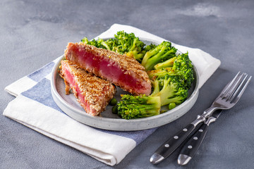 Fried tuna with vegetables served with fork and knife