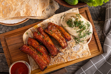 Bbq pork ribs on a wooden board. Top view
