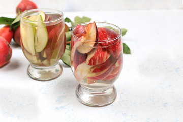 Apple and pear cider, juice or fruit drink in a glass on a sunny table. The concept of diet and weight loss. Apples help cleanse the body and reduce weight. Healthy eating,