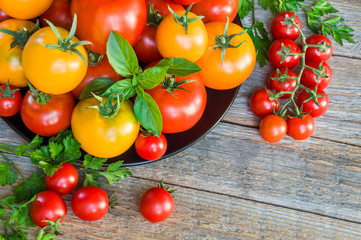 Fresh ripe tomatoes on a plate on a wooden table