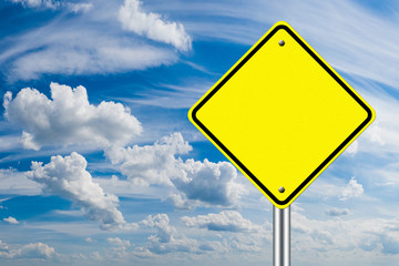 A warning road sign without an inscription on a blue sky background. Yellow warning road sign without text or drawing. Place for text. Your text on the road sign.