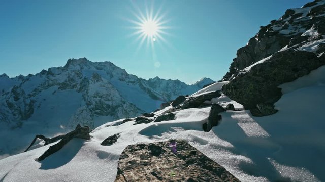 Snow capped mountains above clouds in a blue sky in sunny weather
