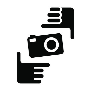 Two hands form a picture frame with camera icon. Photo sign black symbol on white background.