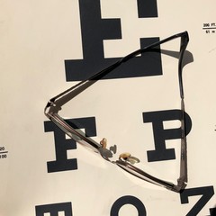 A pair of eye glasses rests on a vision screening chart