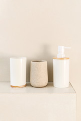 Beige jars for bathroom. Cosmetic accessories on shelf bathroom.