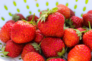 Background from freshly harvested strawberries, directly above. Summer photo with beautiful and juicy strawberries. Fresh organic berries macro. Red ripe. Close up, isolated. 