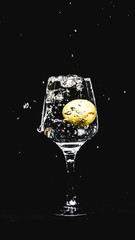 fresh water splashing, while a lemon falling in to a wine glass.