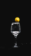 fresh water splashing, while a lemon falling in to a wine glass.