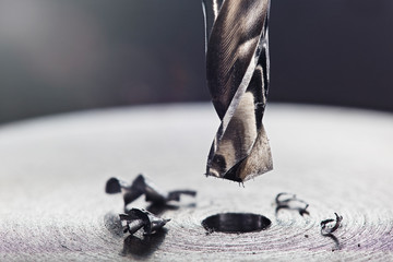 metal drill bit make holes in steel billet on industrial drilling machine. Metal work industry....