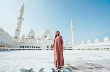 Printed roller blinds Abu Dhabi A young girl in hijab stands against the background of the abu dhabi mosque.