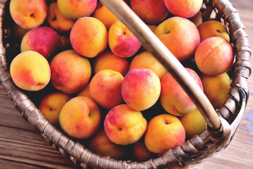 Naklejka na ściany i meble Natural ripe apricots in a wicker basket top view