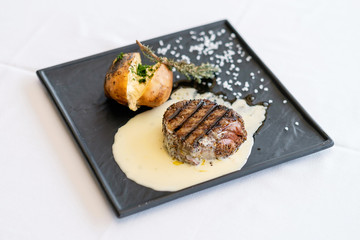 Beef steak with creamy mustard sauce and baked with cottage cheese potatoes. Pretty homemade meal. Cooking and baking food while quarantining  at home during the coronavirus pandemic.