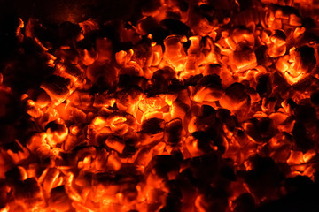 Hot and burning coals in a brazier at night.