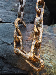 Hook on a chain hanging against a wooden background