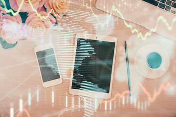 Multi exposure of forex graph hologram over desktop with phone. Top view. Mobile trade platform...