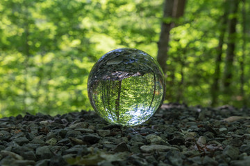 lensball on the ground of little stones in a forest